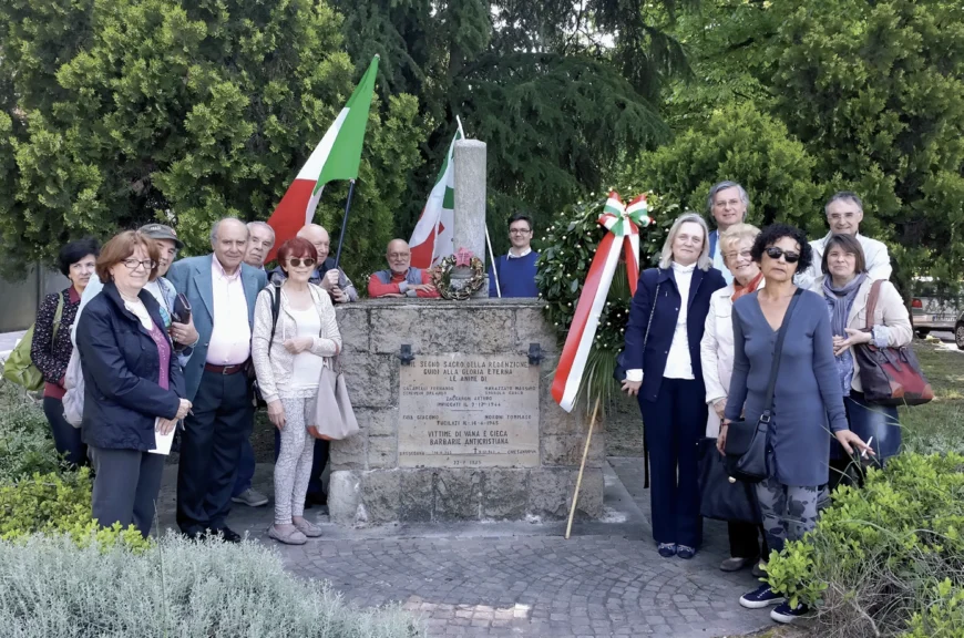 Gruppo di persone davanti a un monumento.